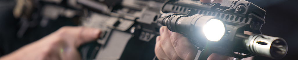 man shooting rifle with a flashlight