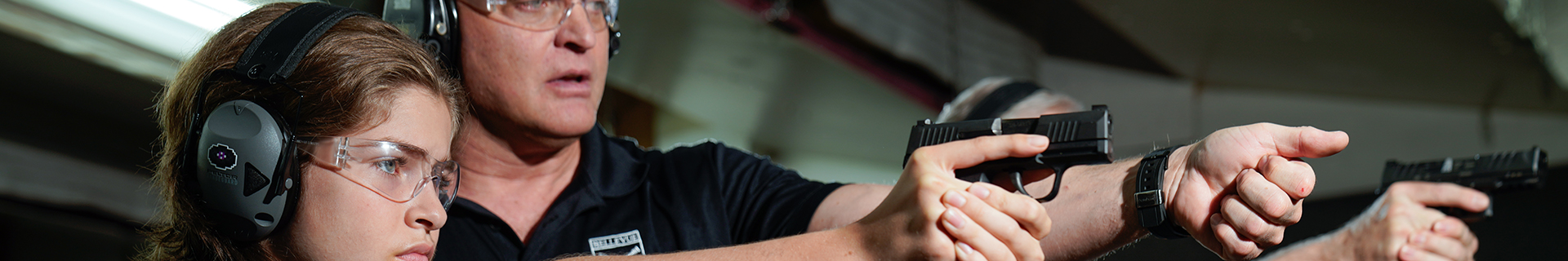 young person receiving instruction on how to hold a handgun